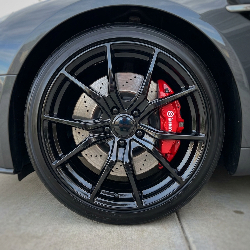 Freshly ceramic-coated black multi-spoke wheel with red Brembo brake caliper